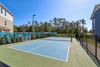 Tennis court with net and surrounding fencing